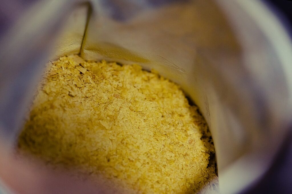 Close-up view inside a bag of nutritional yeast flakes.