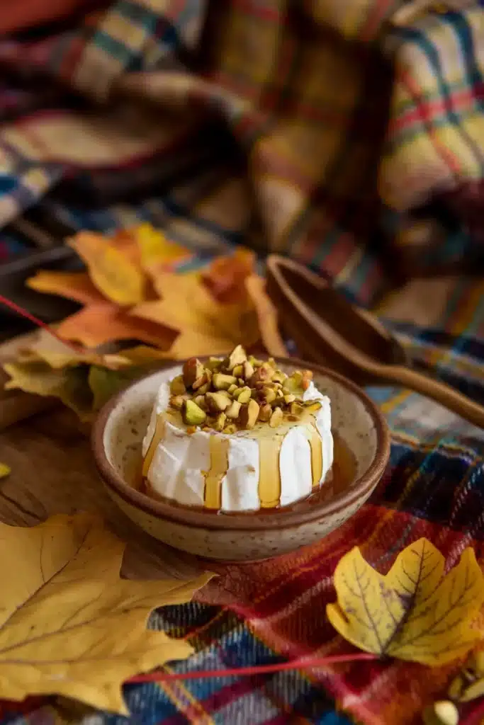 Ricotta cheese with honey and pistachios on a picnic table.